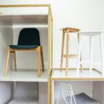 Abstract interior of room with white wall and various chairs placed in boxes and near each other